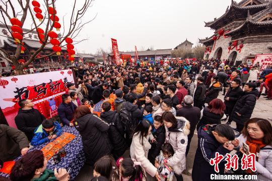 资料图：春节期间，河南建业大食堂吸引众多游客游庙会、吃小吃，拉动消费。　崔悦 摄